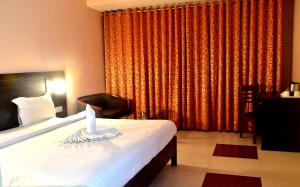 a bedroom with a bed and a large window at Hotel City Inn in Varanasi