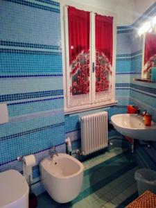 a bathroom with a sink and a toilet and a window at la cana dolce in Bertinoro