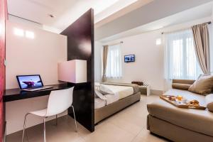 a hotel room with a bed and a desk and a couch at Savoy Hotel in Parma