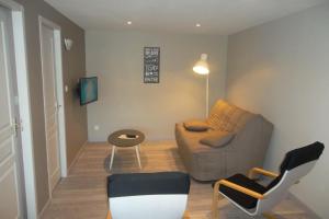 a living room with a couch and a table and chairs at Appartement au centre du tholy pour 5 personnes maximum in Le Tholy