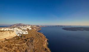 una vista aerea di una scogliera vicino all'acqua di Dreams Luxury Suites a Imerovigli