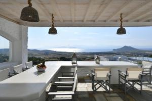 cocina blanca con mesa grande y sillas en Nisides Villa Kostos en Kóstos