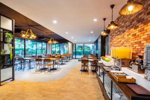 a restaurant with tables and chairs and a brick wall at Livotel Hotel Lat Phrao Bangkok in Bangkok