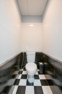 a bathroom with a toilet in a black and white checkered floor at Sindy's Hostel in Pattaya Central
