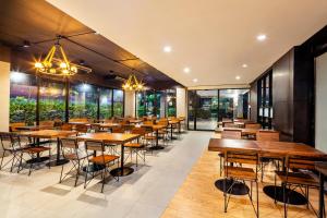 a restaurant with wooden tables and chairs and windows at Livotel Hotel Lat Phrao Bangkok in Bangkok
