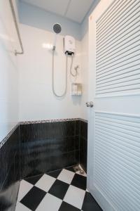 a bathroom with a shower and a black and white checkered floor at Sindy's Hostel in Pattaya Central
