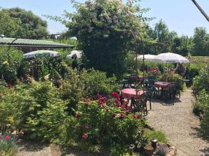a garden with tables and chairs and flowers at Deichschatz in Mittelnkirchen