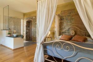 a bedroom with a bed and a stone wall at Relais SANT'AMBROGIO in Bobbio
