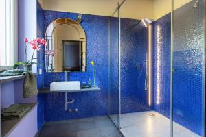 a blue tiled bathroom with a sink and a shower at Relais SANT'AMBROGIO in Bobbio