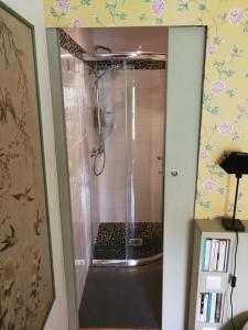 een douche met een glazen deur in de badkamer bij La Forge in Arcis-le-Ponsart