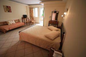 a bedroom with a bed and a living room at Malou Apartments in Kato Daratso
