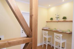 a small kitchen with a bar with two white stools at Lx Flowers Apartments in Lisbon