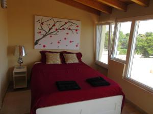 a bedroom with a bed with a red bedspread at Villa Maria Louiza NEAR AIRPORT in Artemida