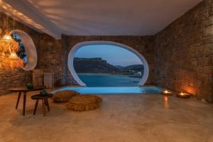 an indoor swimming pool with an archway in a room at Panormos Village Hotel in Mykonos