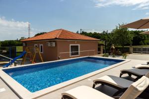 una piscina con sedie e una casa di Villa Astra a Barban