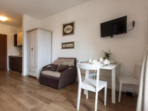 a living room with a white table and a couch at VacationClub – Aquamarina Apartament C-19 in Świnoujście