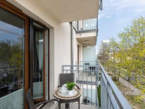 a balcony with a table with a plant on it at VacationClub – Aquamarina Apartament C-19 in Świnoujście