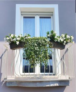 a window with two potted plants on a balcony at Romantic Home in Sirmione