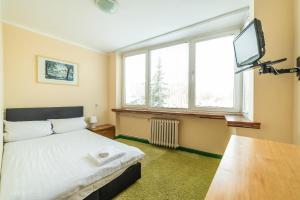 a bedroom with a bed and a flat screen tv at Sopocki Zdrój in Sopot