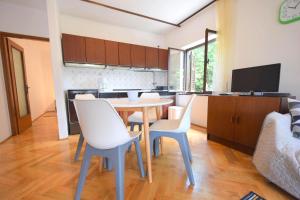 kuchnia i jadalnia ze stołem i krzesłami w obiekcie Apartments Jadanec w mieście Malinska