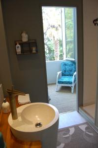 La salle de bains est pourvue d'un lavabo, d'une chaise et d'une fenêtre. dans l'établissement Madeleine Bergerac, à Bergerac