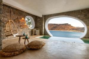 a living room with a balcony overlooking a lake at Panormos Village in Mykonos