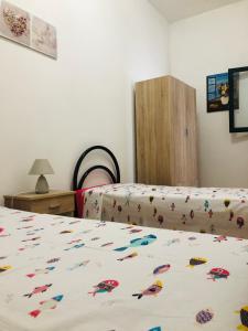 Un dormitorio con 2 camas y una colcha con pescado. en Appartamento Renis en Sant'Isidoro