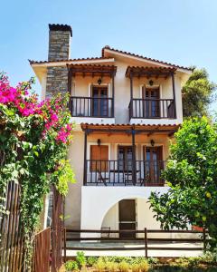 a white house with balconies and pink flowers at Koel Country House in Áno Almirí