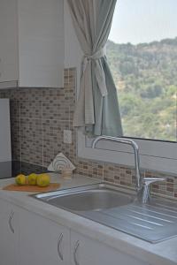 a kitchen counter with a sink and a window at MARE VISTA in Evdilos +42 photos