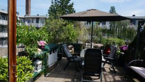 een patio met een parasol, stoelen en planten bij Amsterdam Roof Terrace B&B in Amsterdam