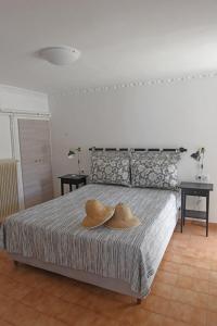 ein Schlafzimmer mit einem Bett mit zwei Hüten darauf in der Unterkunft MARE VISTA in Évdilos