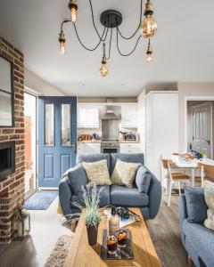 a living room with a couch and a table at Owlers Cottage in Camber