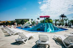 einen Pool mit Stühlen und einer Wasserrutsche in der Unterkunft Green Apartment Spa n Pool Beach Resort in Mamaia Nord – Năvodari