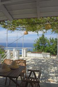 einen Tisch und Stühle auf einer Terrasse mit Meerblick in der Unterkunft MARE VISTA in Évdilos