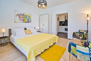 a bedroom with a large yellow bed and a kitchen at Apartments Juric in Hvar