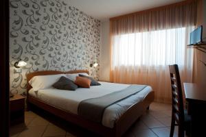 sypialnia z łóżkiem i dużym oknem w obiekcie Hotel Oasi Verde w mieście Bienno