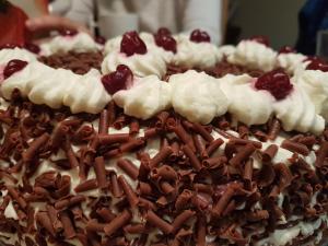 a chocolate cake with whipped cream and cherries on it at Ancien Presbytère Albert Schweitzer in Gunsbach