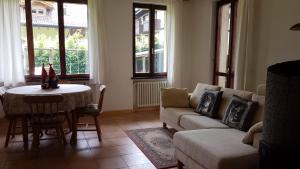 - un salon avec un canapé et une table dans l'établissement Alisea Home, à Pinzolo