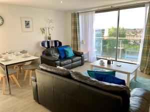 uma sala de estar com um sofá e uma mesa em Principal Apartments - Clyde Waterfront Apartments em Glasgow