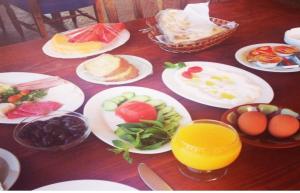 een houten tafel met borden met eten en drinken bij Ahiram Hotel Byblos in Jbeil