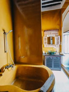 a bath tub in a bathroom with yellow walls at Kholle House in Zanzibar City