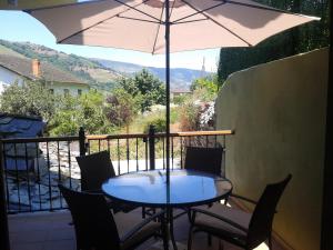 a table and chairs with an umbrella on a balcony at El Mirador De Limes in Cangas del Narcea