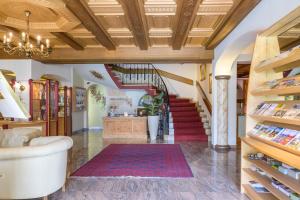 a living room with a staircase and a rug at Glanzhof Hotel & Apartments in Marlengo