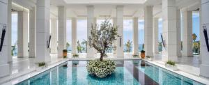 a pool with a tree in the middle of a building at Amavi, MadeForTwo Hotels - Paphos in Paphos