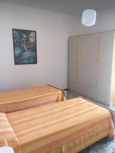 sypialnia z 2 łóżkami i zdjęciem na ścianie w obiekcie CASA RENATA w mieście Castellabate