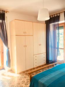 a bedroom with white cabinets and a blue bed at CASA RENATA in Castellabate