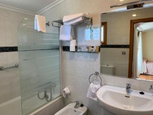 a bathroom with a sink and a toilet and a mirror at Hotel Miramar Playa America Nigran in Nigrán
