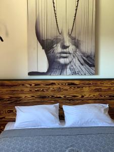 a bed with a wooden headboard with a picture above it at Air Loft Apartment in Kyiv
