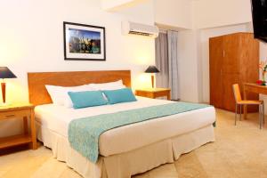 a bedroom with a large bed with blue pillows at Hotel Oceania Cartagena in Cartagena de Indias +101 photos