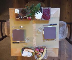 a table with food and a basket of fruit on it at I Chimi Locanda di Frassino in Frassino
